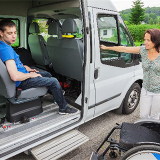 man in accessible van with woman leaning on the van next to a wheelchair
