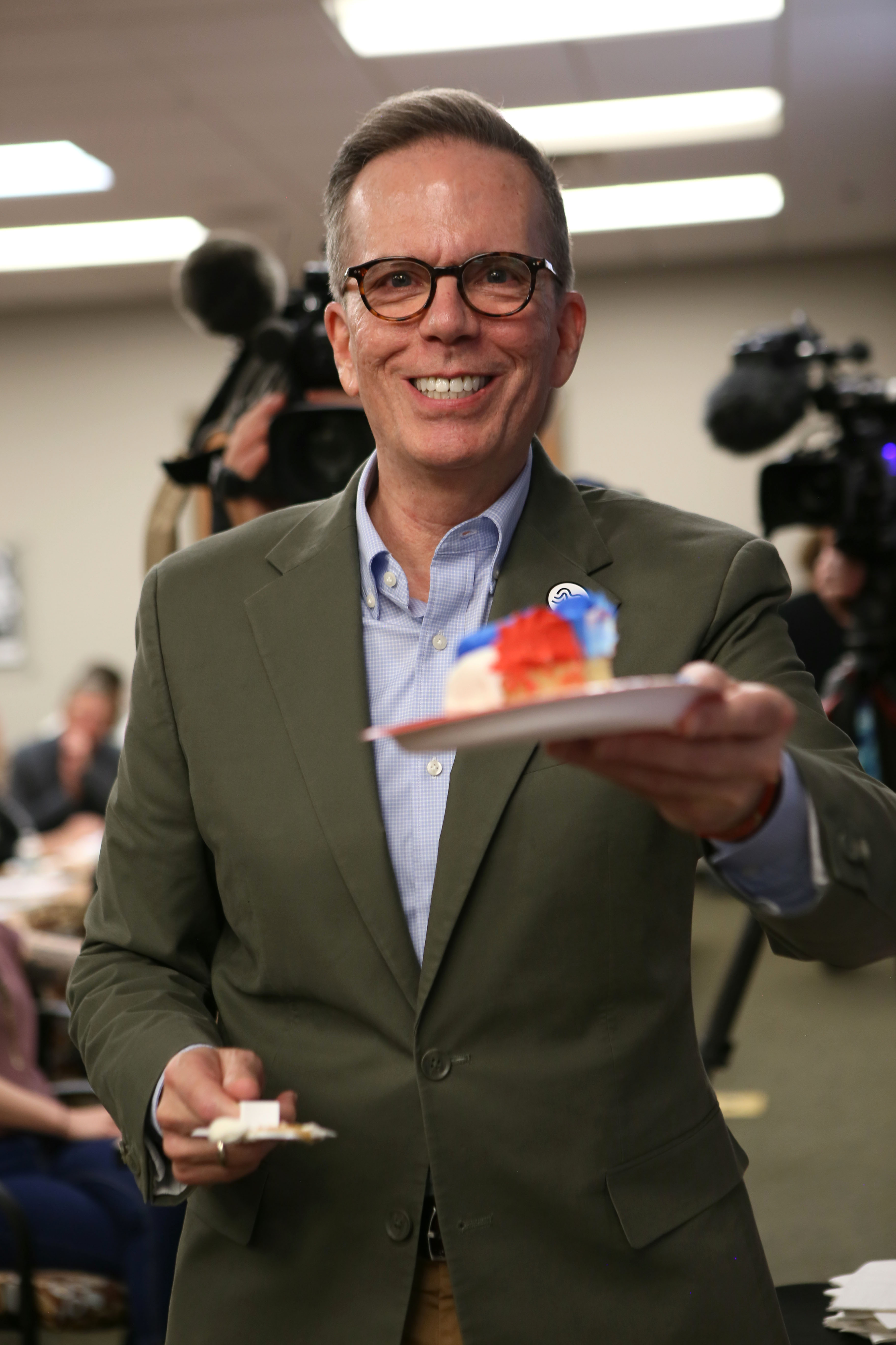 Tony Snell Rodriguez, Director of Community Engagement and Inclusion at Visit Milwaukee and Chair of the Equal Rights Commission, poses with a slice of cake