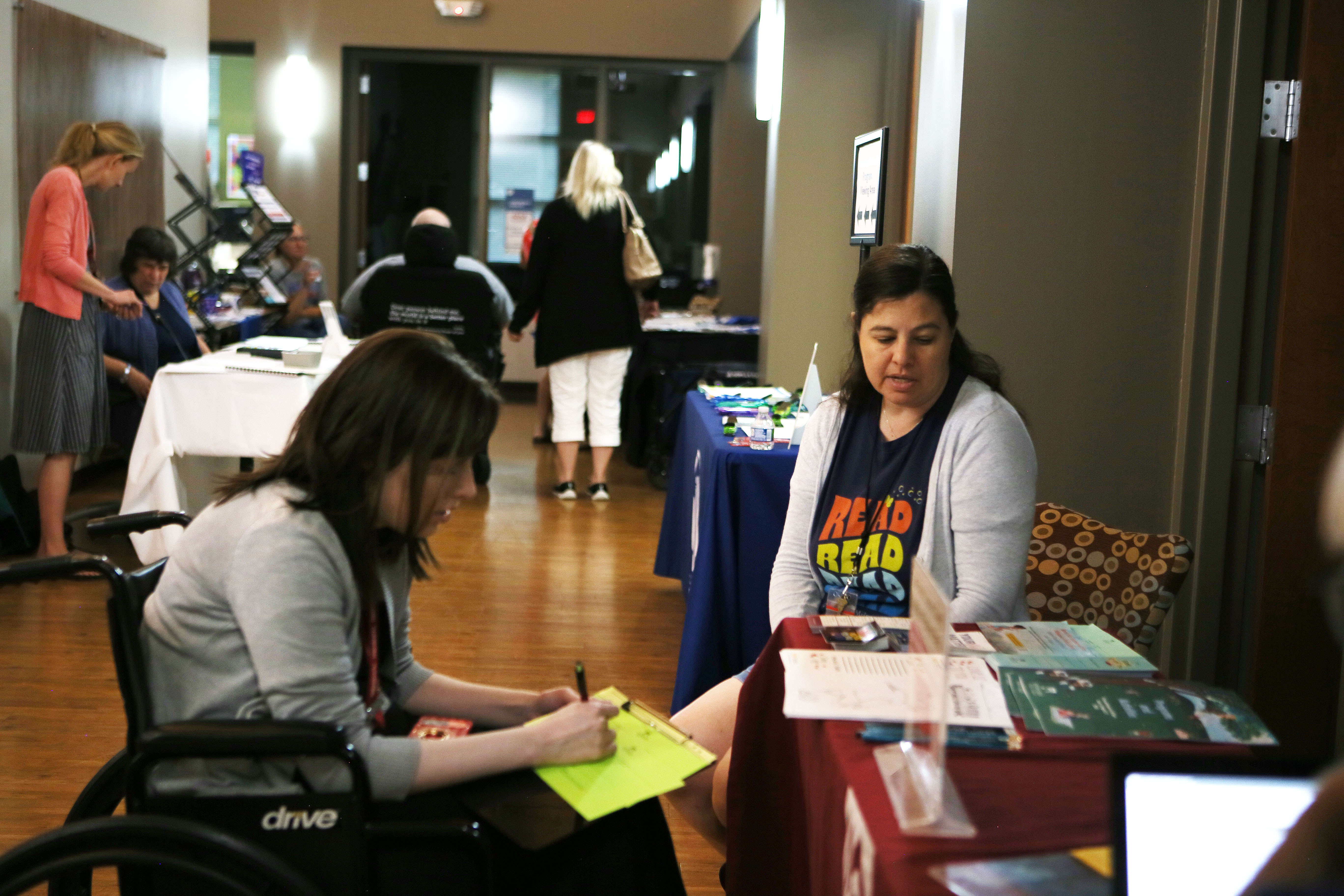 A member of the Milwaukee Public Library Outreach Team talks to an event attendee