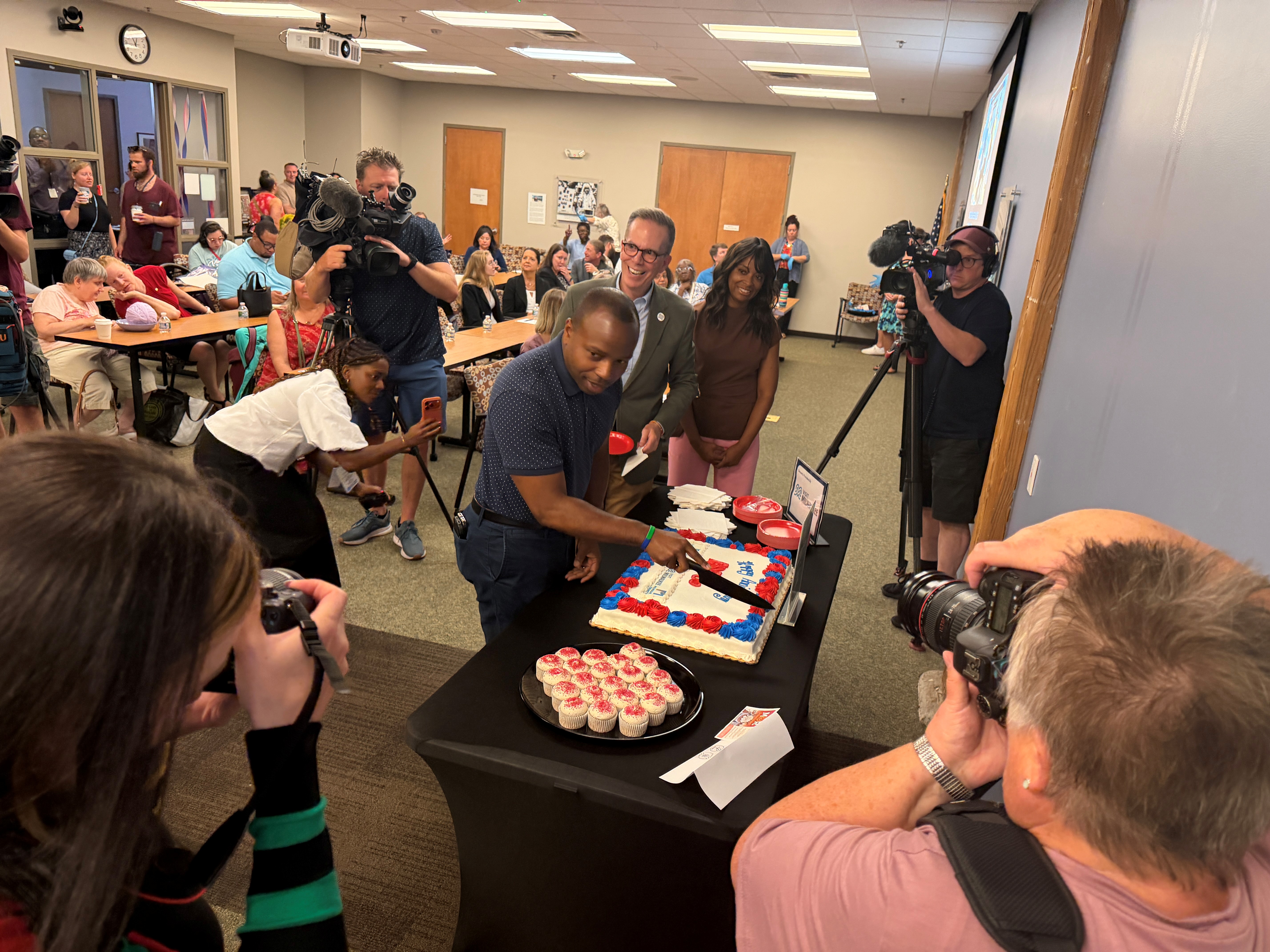 Milwaukee Mayor Cavalier Johnson cuts a cake celebrating the 36th anniversary of the Americans with Disabilities Act during Independence First's anniversary celebration.