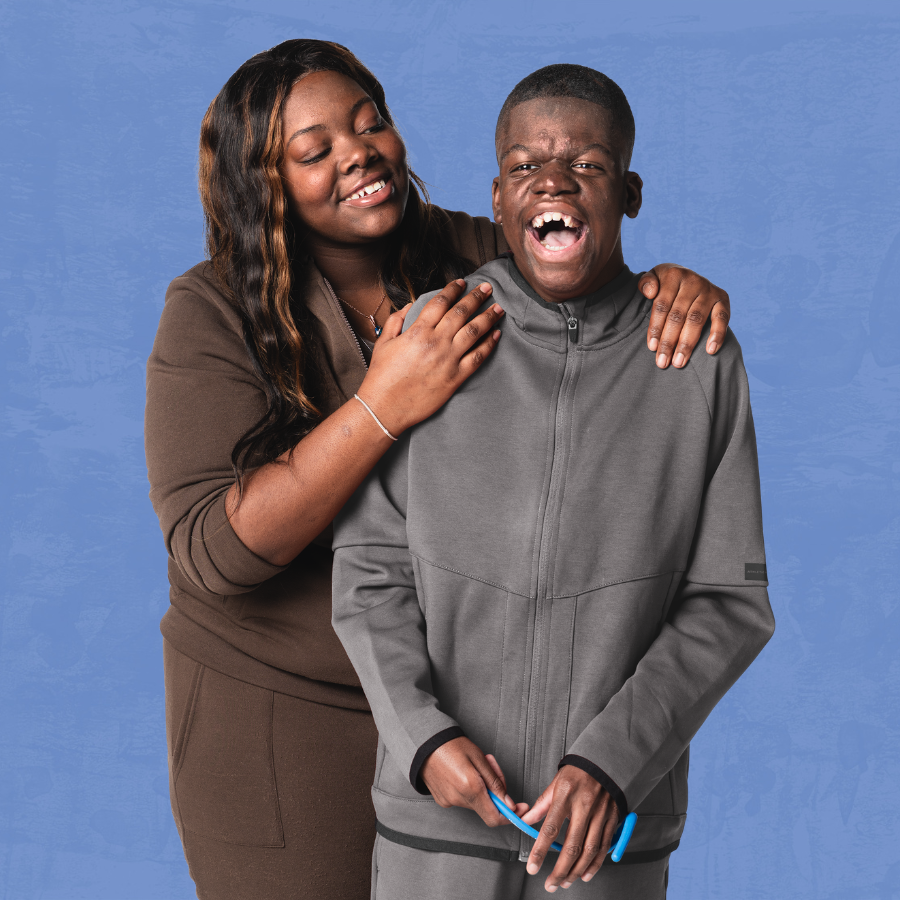 A consumer holding a fidget and his caregiver laugh together