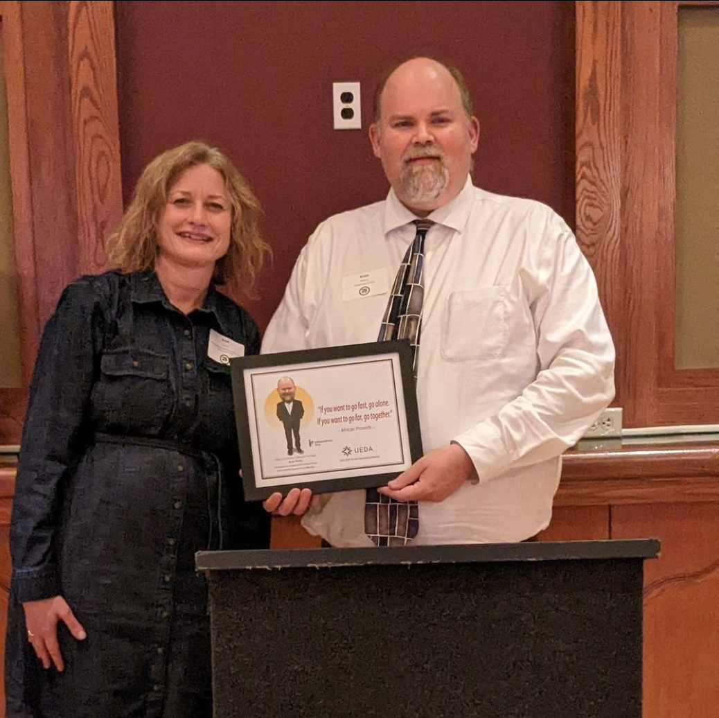 Brian Peters accepts award from UEDA