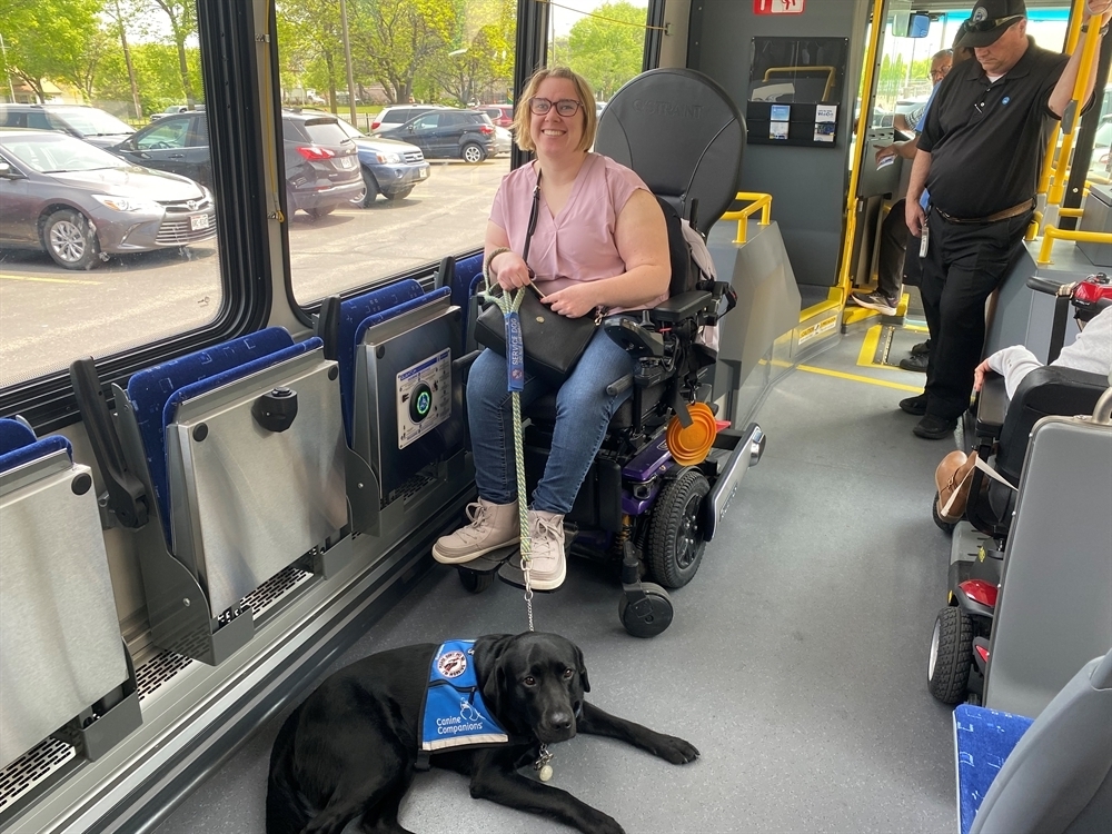 Emily and her service dog Venus try the new locking system on the electric bus