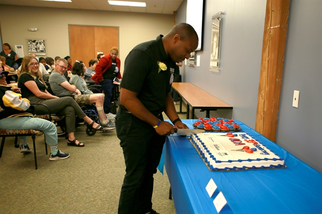 Photo of Mayor Cavalier Johnson ceremoniously cutting the cake