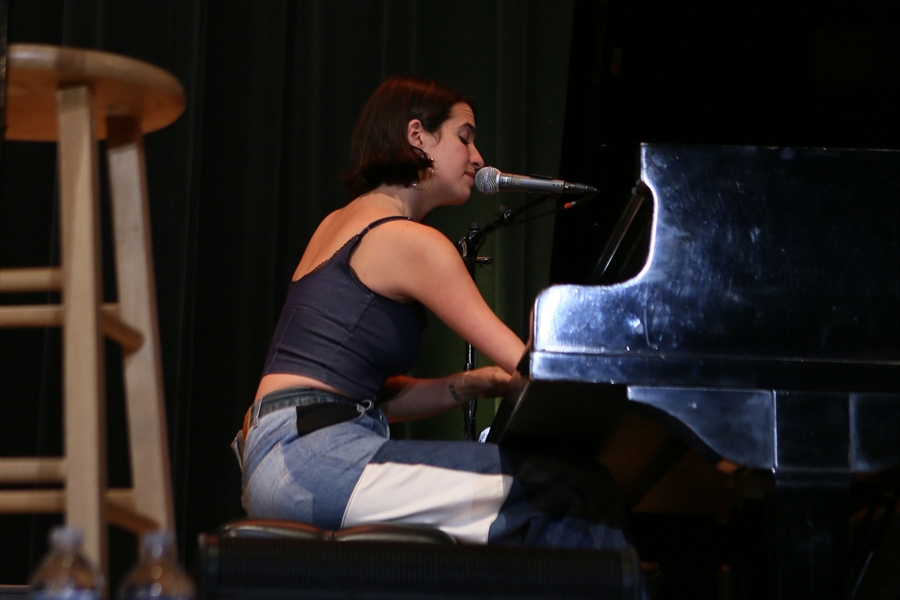 Victoria sings at a grand piano