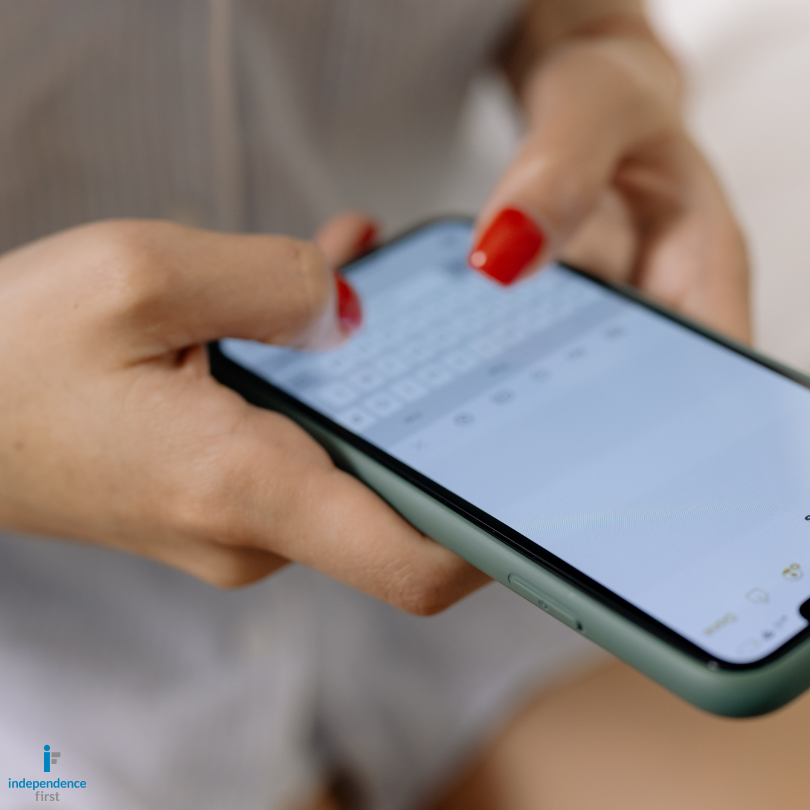 Close-up of a person holding a smartphone with one hand while using the touchscreen keyboard with th