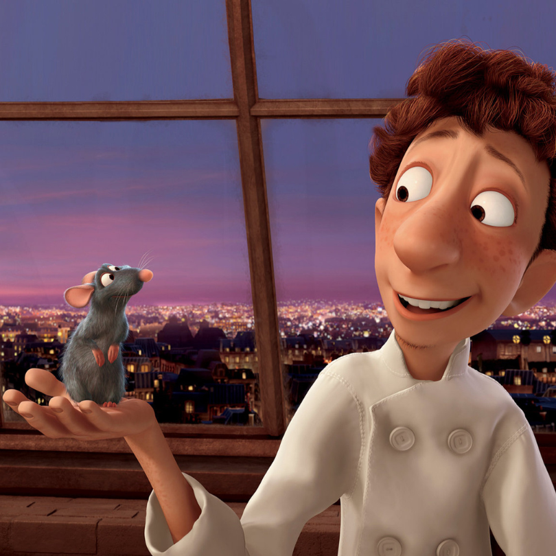 Animated scene from Ratatouille showing a smiling young chef holding a small gray rat in his open ha