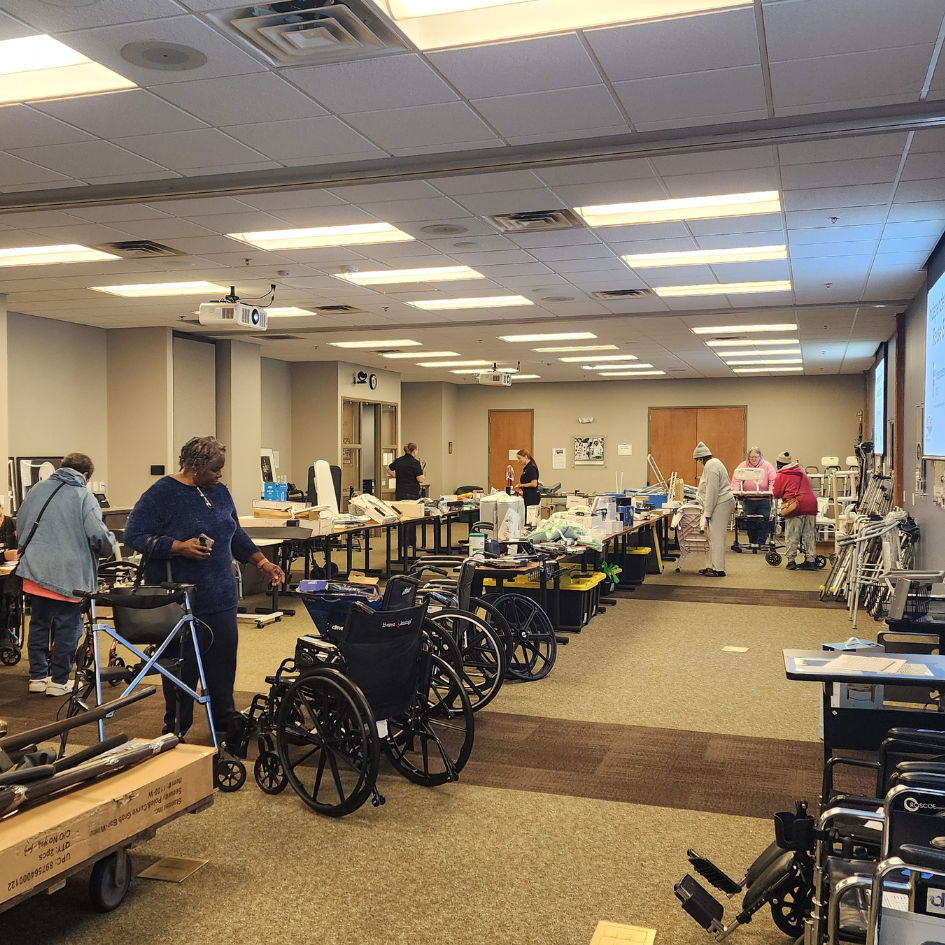 People looking through a room full of adaptive devices like wheelchairs and walkers at Independence 