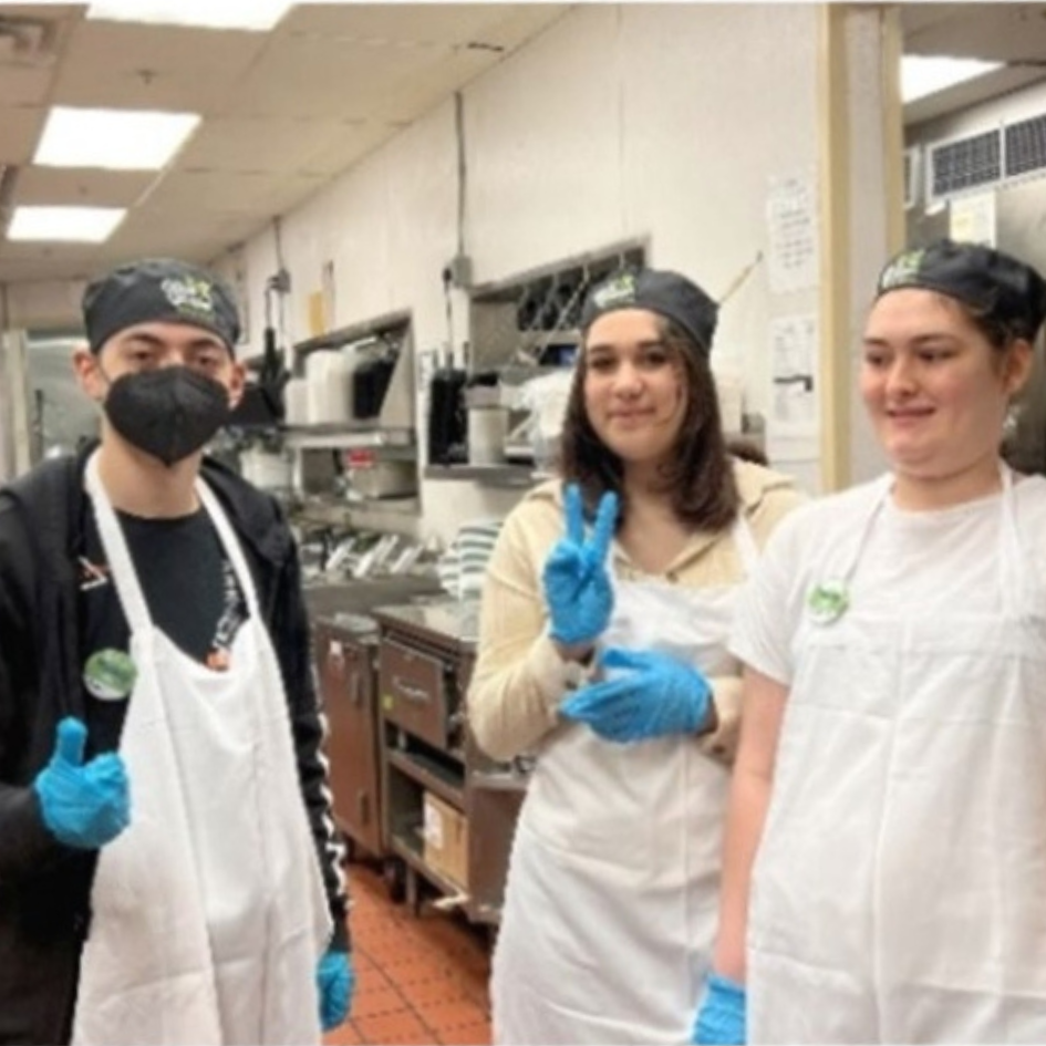 Disability mentoring month participants dressed in aprons and gloves job shadowing in the kitchen at