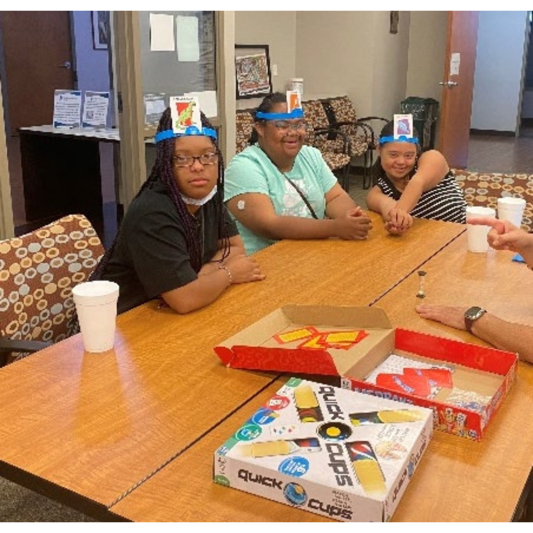 A group of teens play a board game at a table