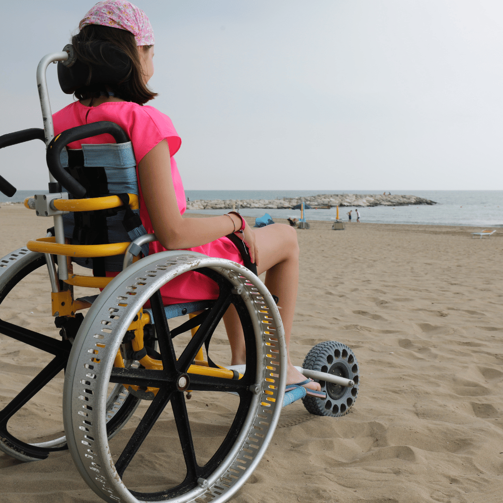 Image of a girl in a beach-friendly wheelchair on a sunny day