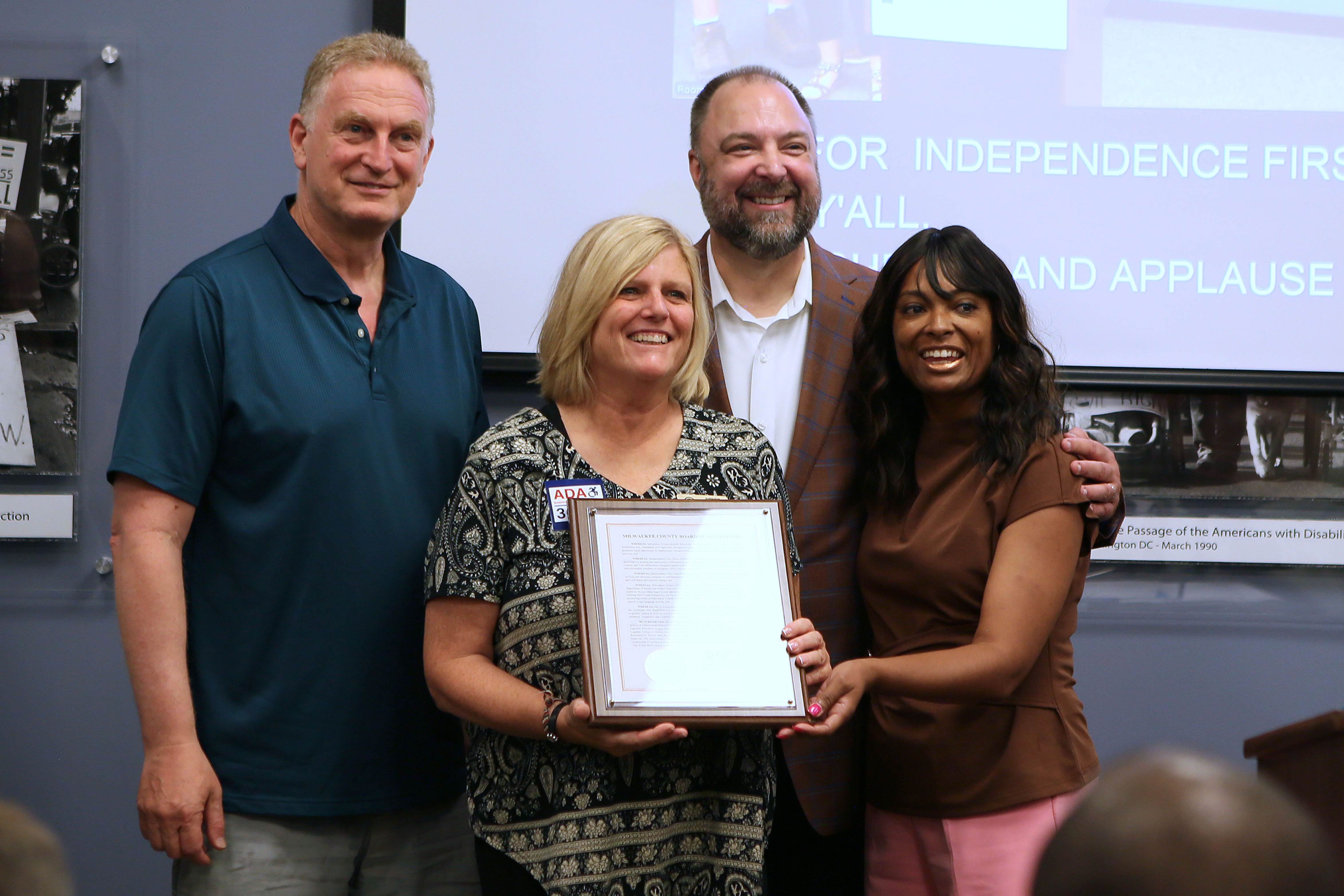 County Supervisors Sheldon Wasserman and Kathleen Vincent pose with Director of Health and Human Services Shakita LaGrant-McClain and Fund Development Director Troy Moldenhauer to present a citation recognizing the 36th Anniversary of the ADA