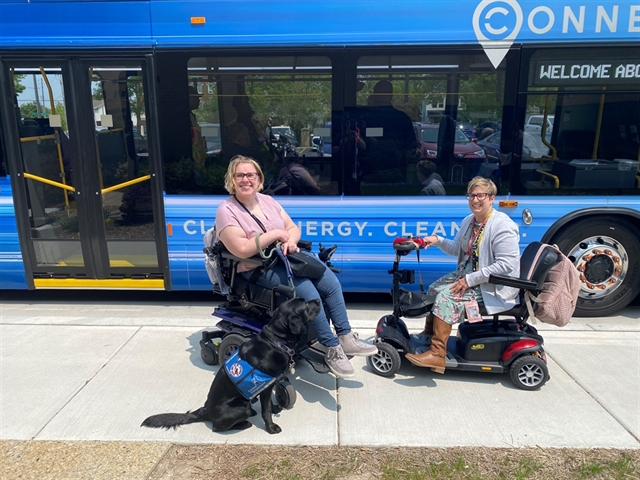 Emily and Raquella pose in front of the new electric bus