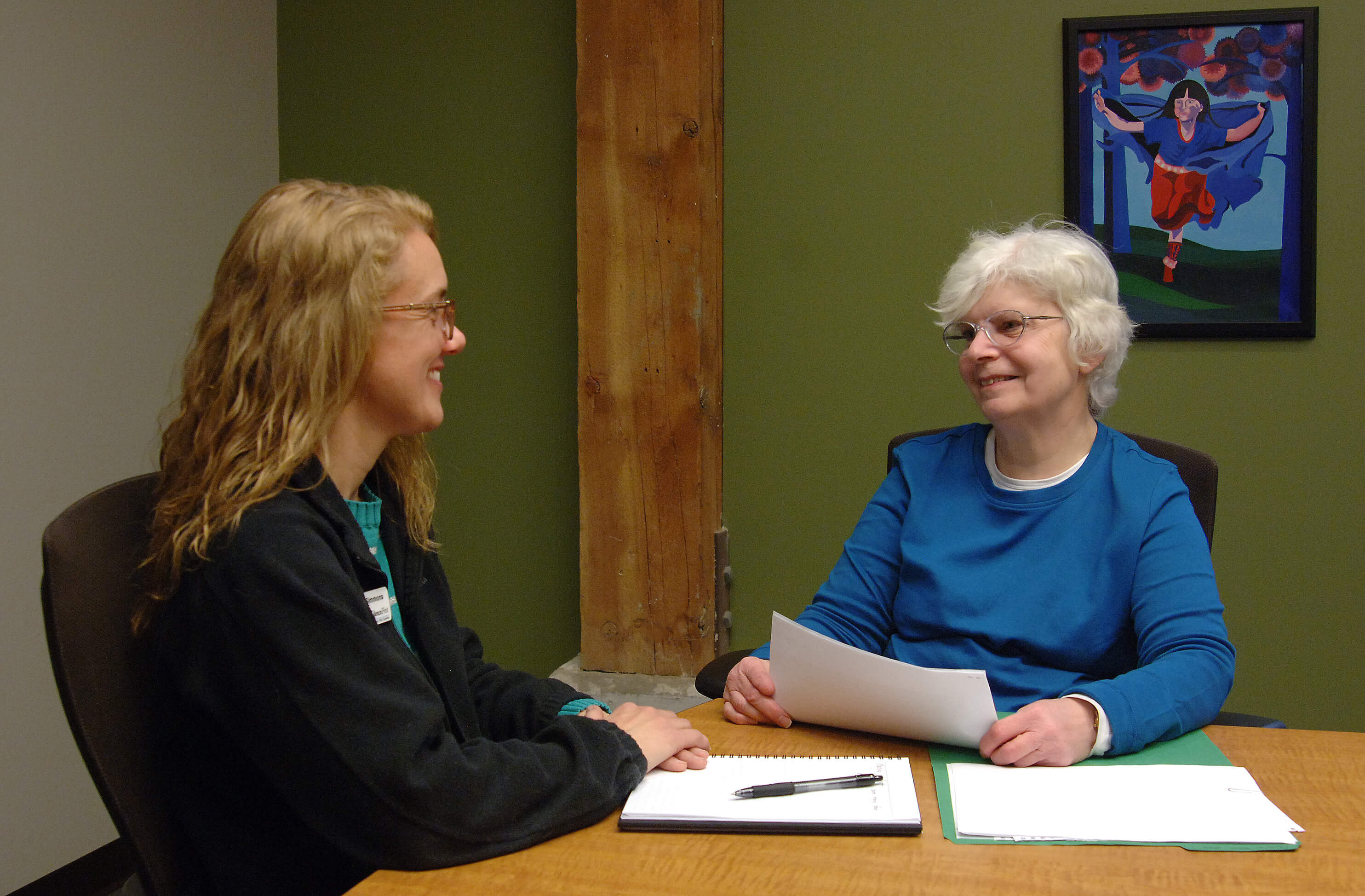 Two women smiling and sitting at a table