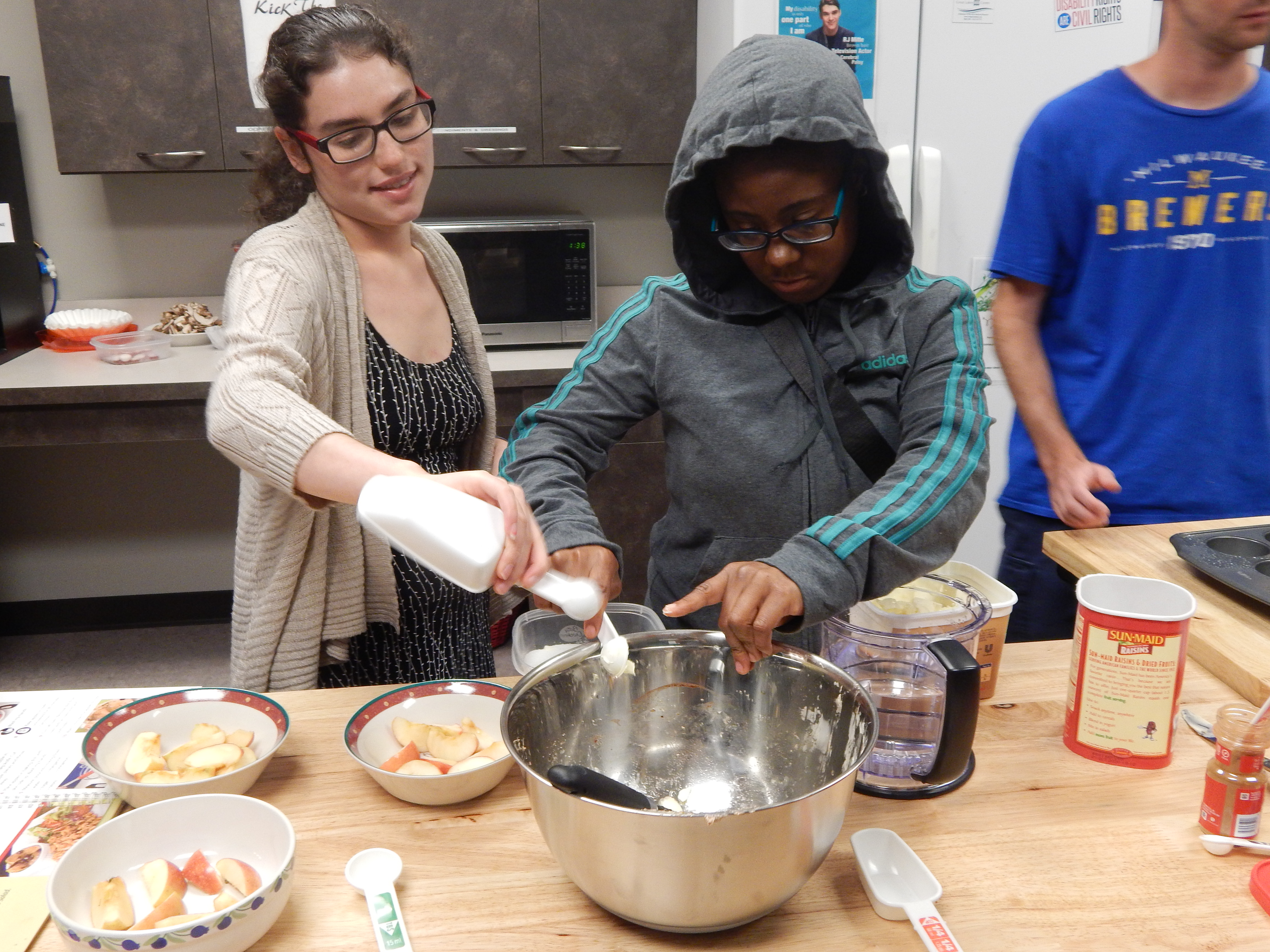 Two individuals working together in the kitchen.
