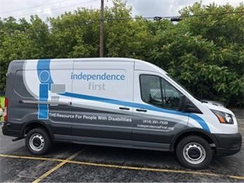 The Independence First transit van. It's white with the Independence First logo printed on the side.