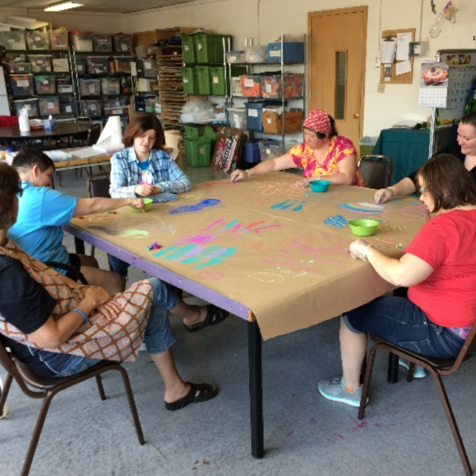 Participants at craft and chat work on a project together