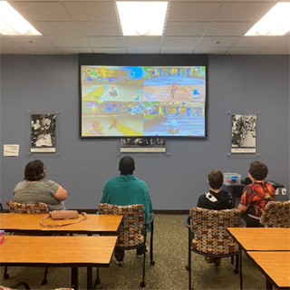 Participants in game night play a video game at Independence First