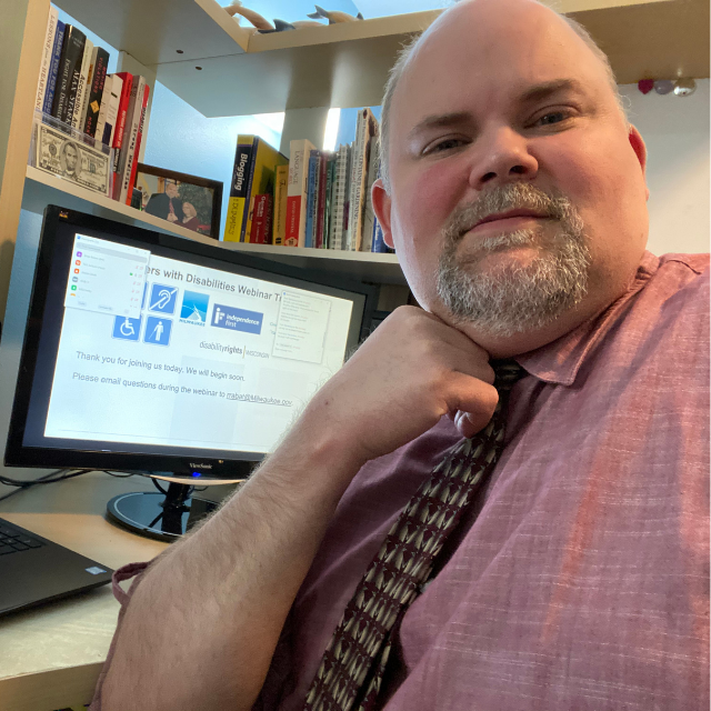 White man sitting in front of computer screen
