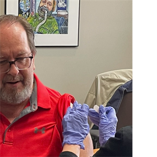 A nurse gives a man a vaccine in his arm